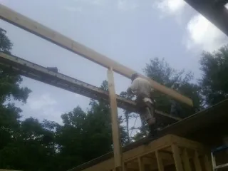 Carpenter setting a ridge beam over a new addition frame — Ice Dam Removal by Roofing Brothers in Libertytown