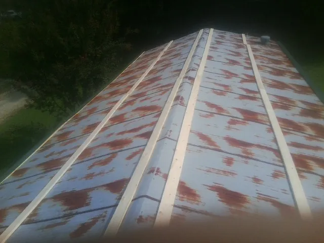 Rusted metal roof panels with new wood purlins before replacement — Storm Damage Roof Repair in Libertytown by Roofing Brothers